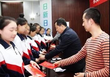 捐赠企业的经理与参会领导向受助学生发放救助资金