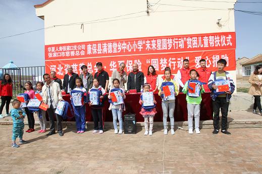 参加帮扶活动仪式的领导向满德堂乡张虎地村、台路沟村走读贫困学生发放慰问金、爱心书包和文具用品。